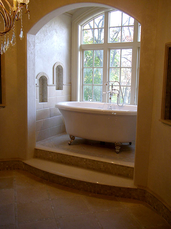Luxurious stone tiles in bathroom with freestanding tub